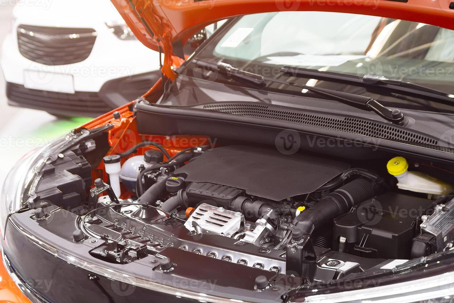 Open hood of a new car revealing engine in auto shop. Transport photo
