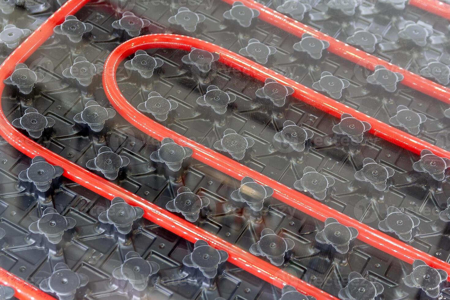 Red pipes laid out in a grid pattern for a radiant heating system photo