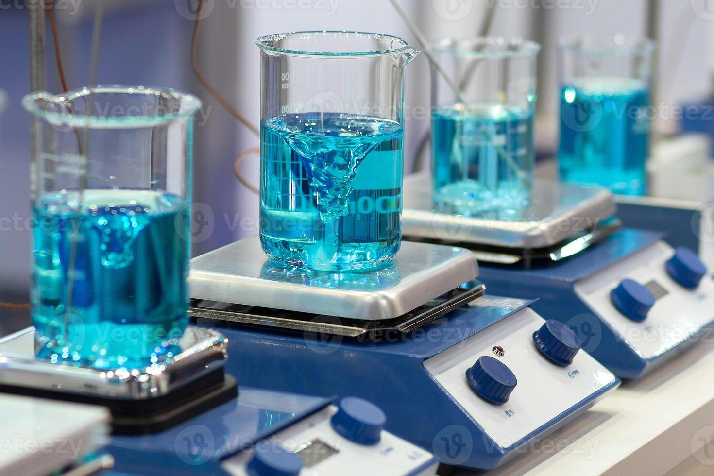 Mixer stirring liquid in beaker in the medical laboratory photo