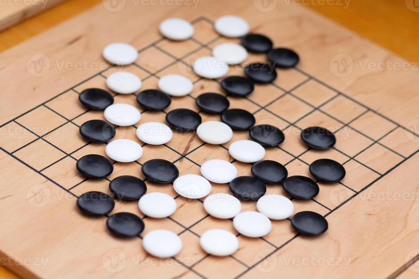 Chinese go game board, close up view of playing black and white stone pieces, Alphago photo