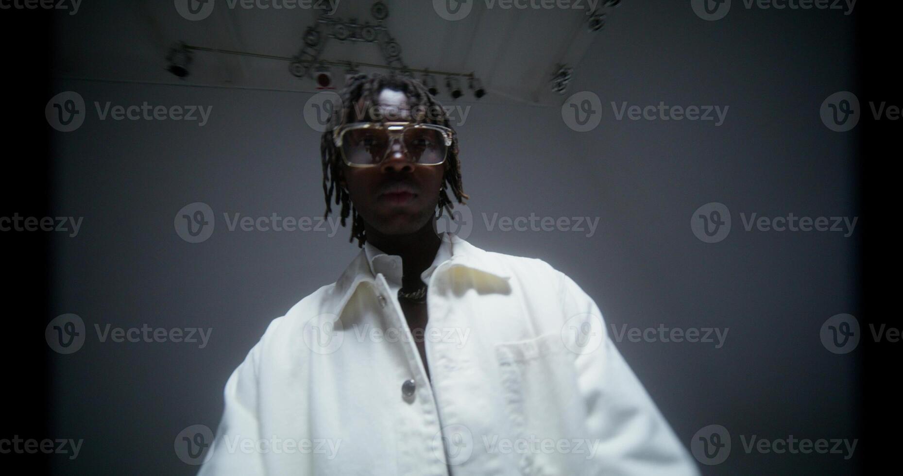 A stylish man raps while looking at the camera. Filming a music in the studio photo