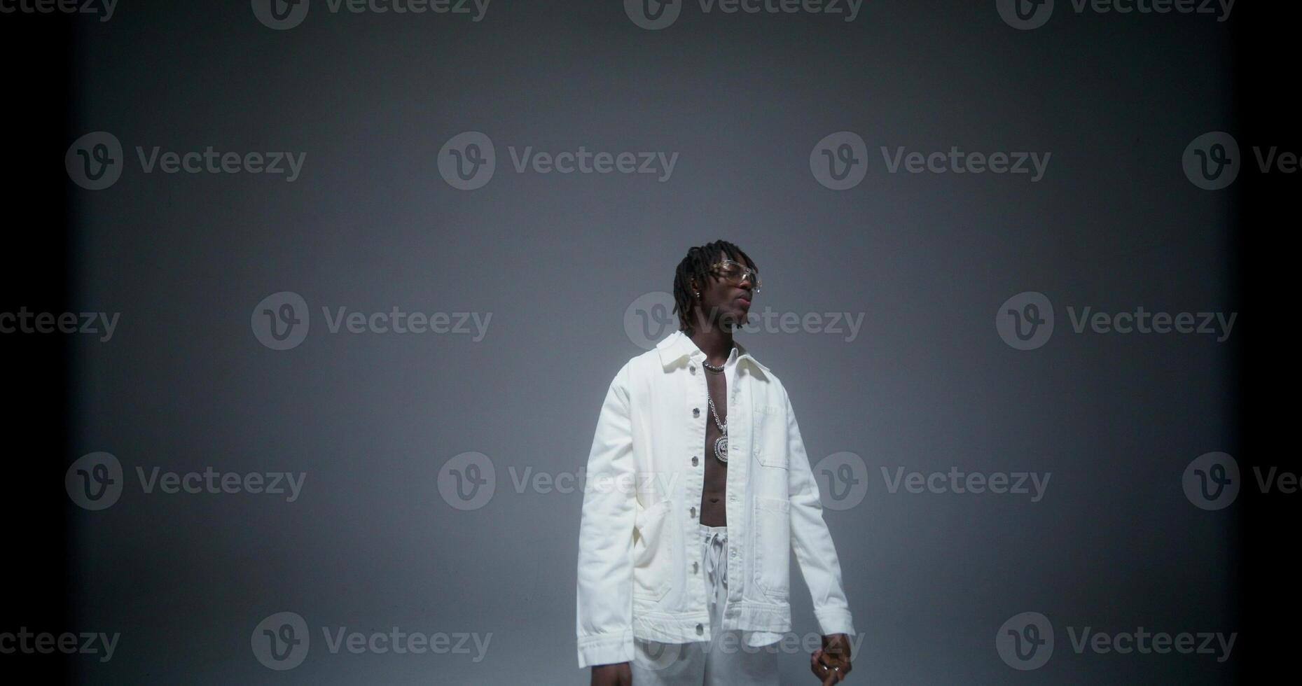 A man is dancing and singing in the studio. He looks at the camera with serious look. Recording the rapper's music photo
