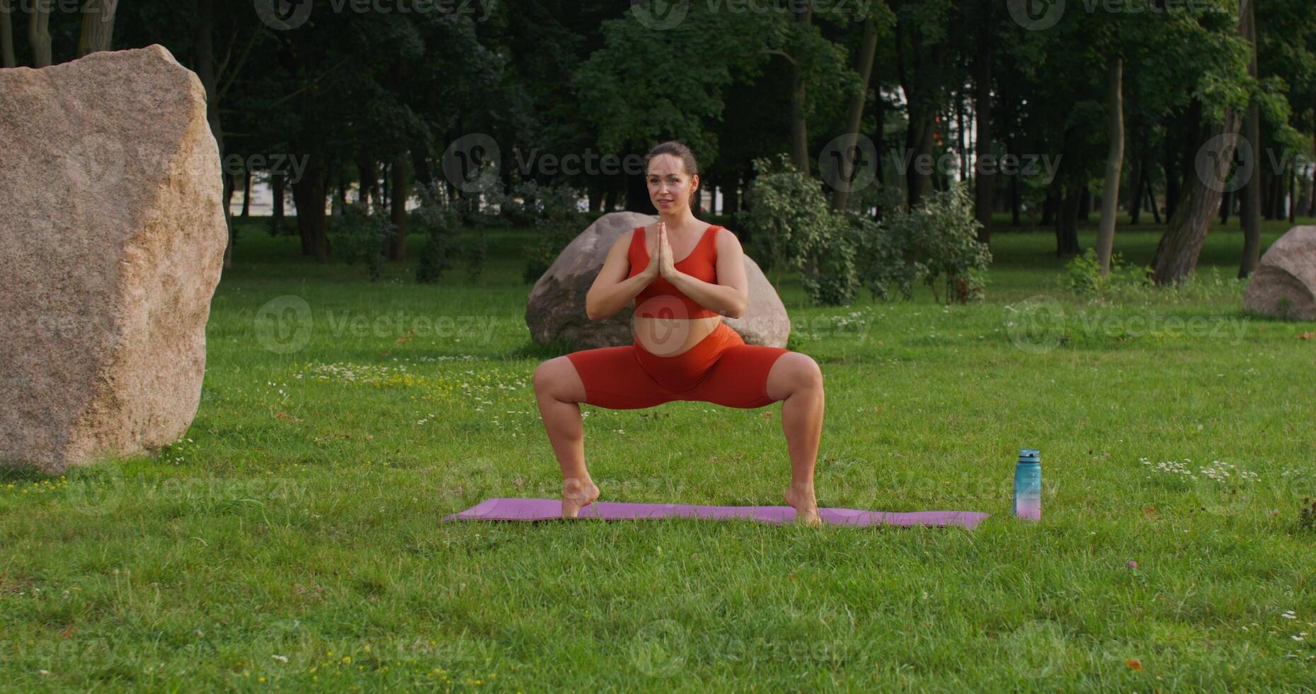 A woman in sports clothes does yoga in a city park. Sports during pregnancy photo