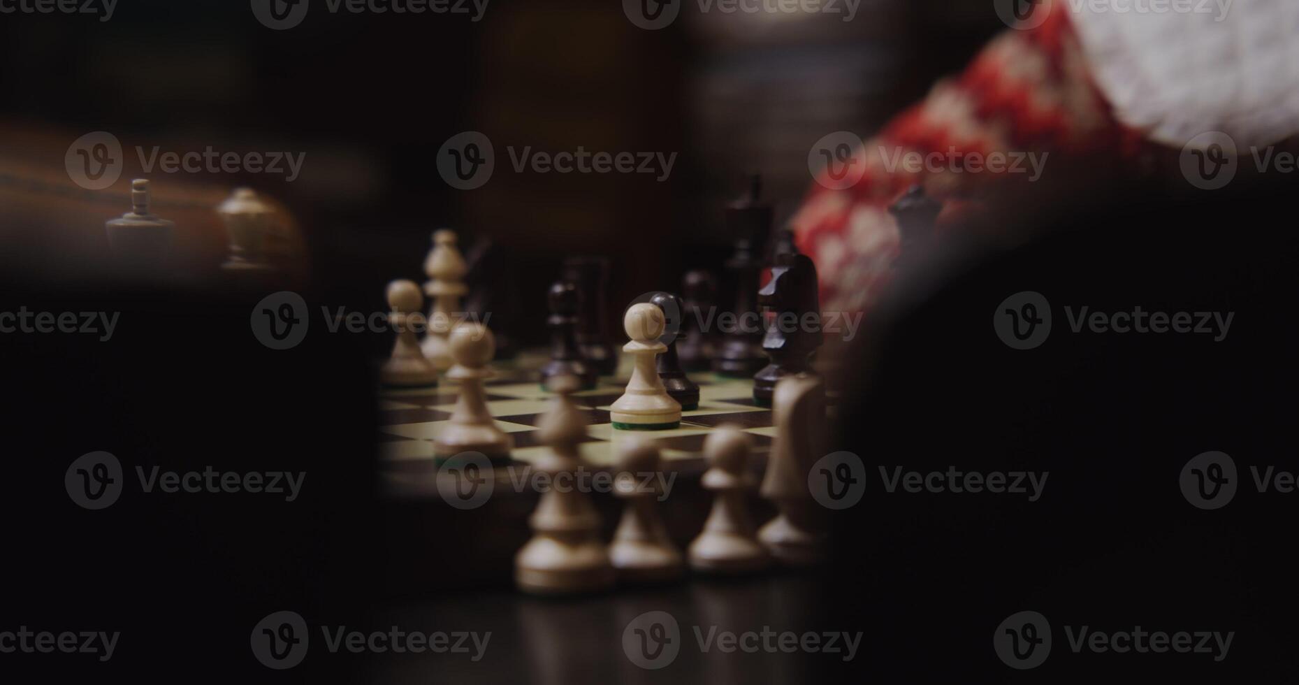 A young woman plays a chess game alone, thinking long concentratedly between moves, sitting at a table, close-up photo