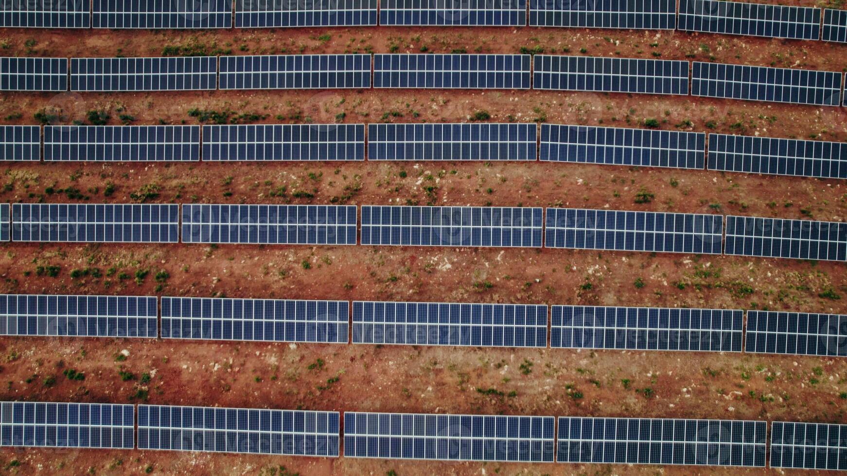 A lot of solar panels lie in straight lines on a deserted land, a bird's-eye view photo