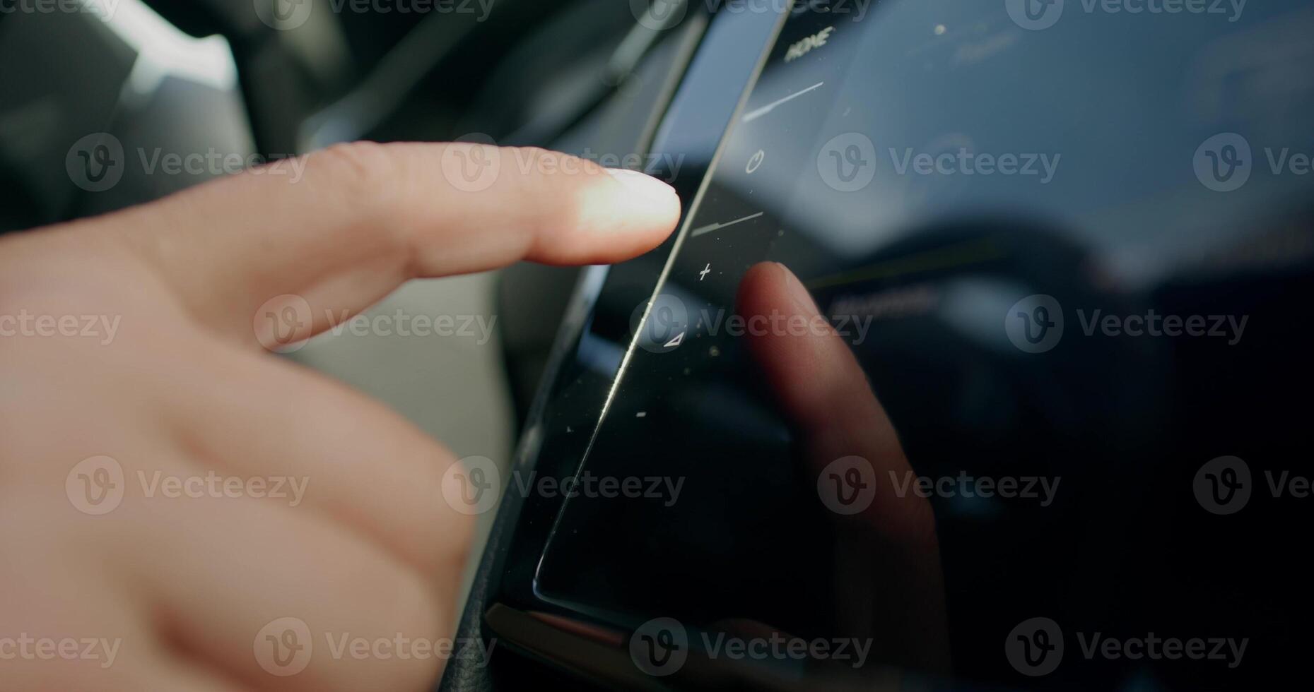 A man uses the control panel while driving a car. Close-up of his hands, an unrecognizable person. View from the car interior. photo
