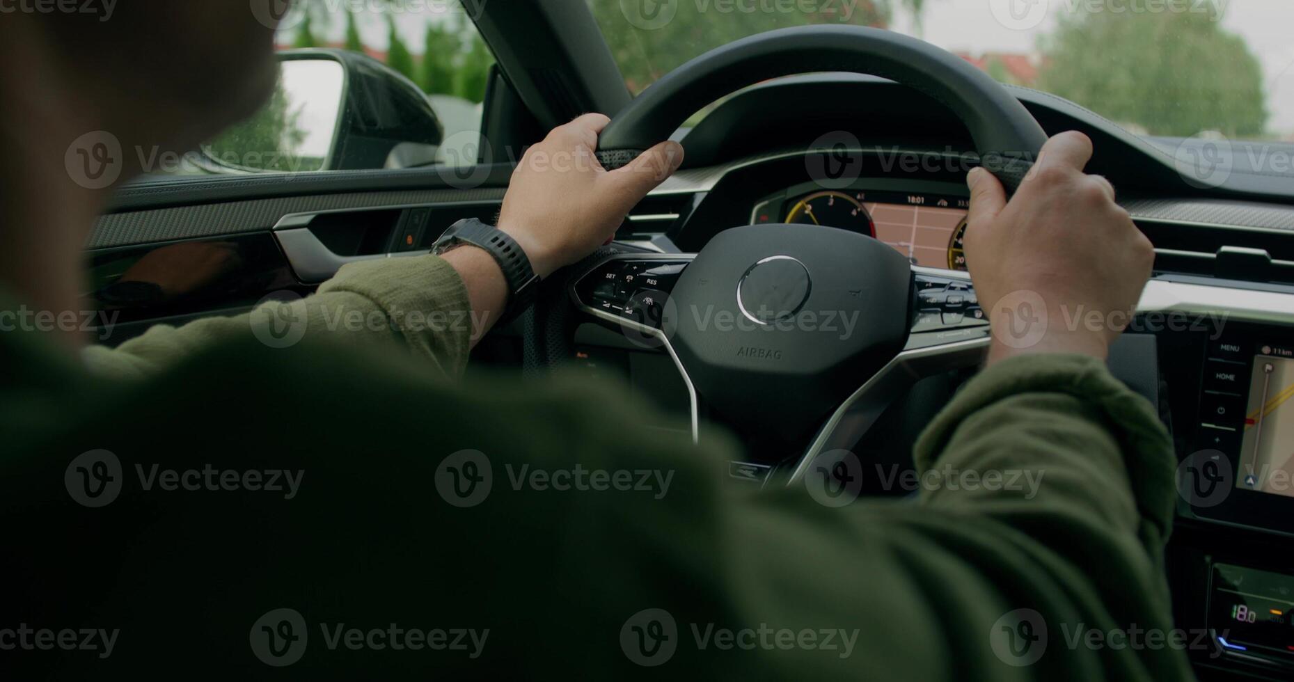 A man drives a car. Close-up of his hands on the steering wheel, an unrecognizable person. View from the car interior. Summer photo