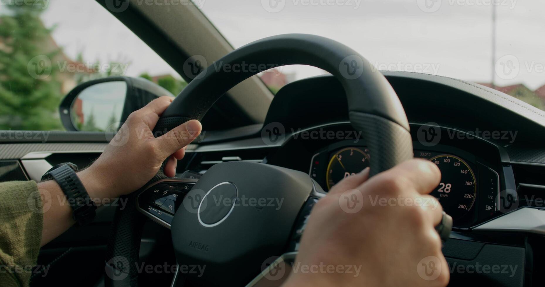A man drives a car. Close-up of his hands on the steering wheel, an unrecognizable person. View from the car photo