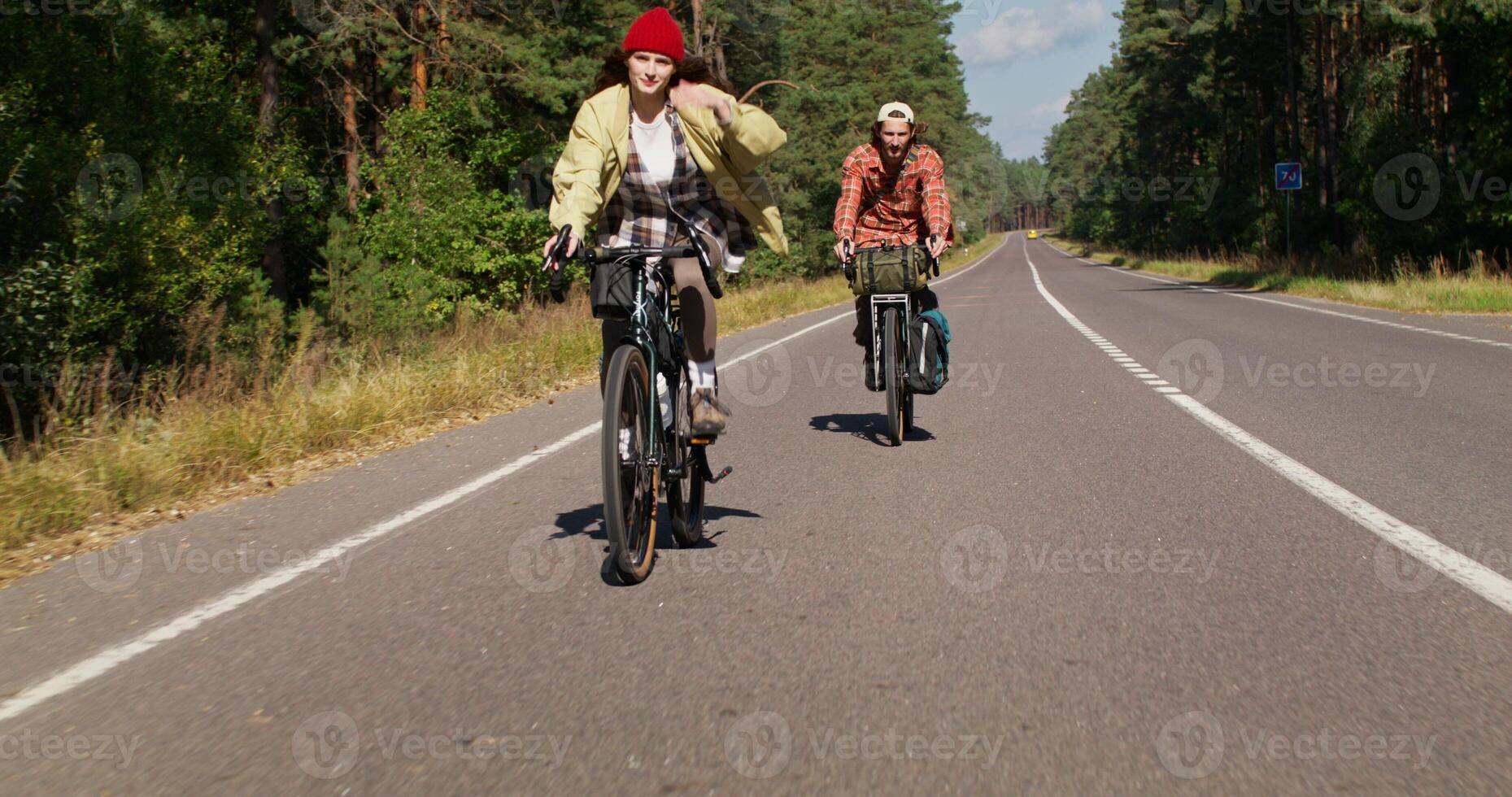 A man and a woman ride bicycles on the road. A cold day photo