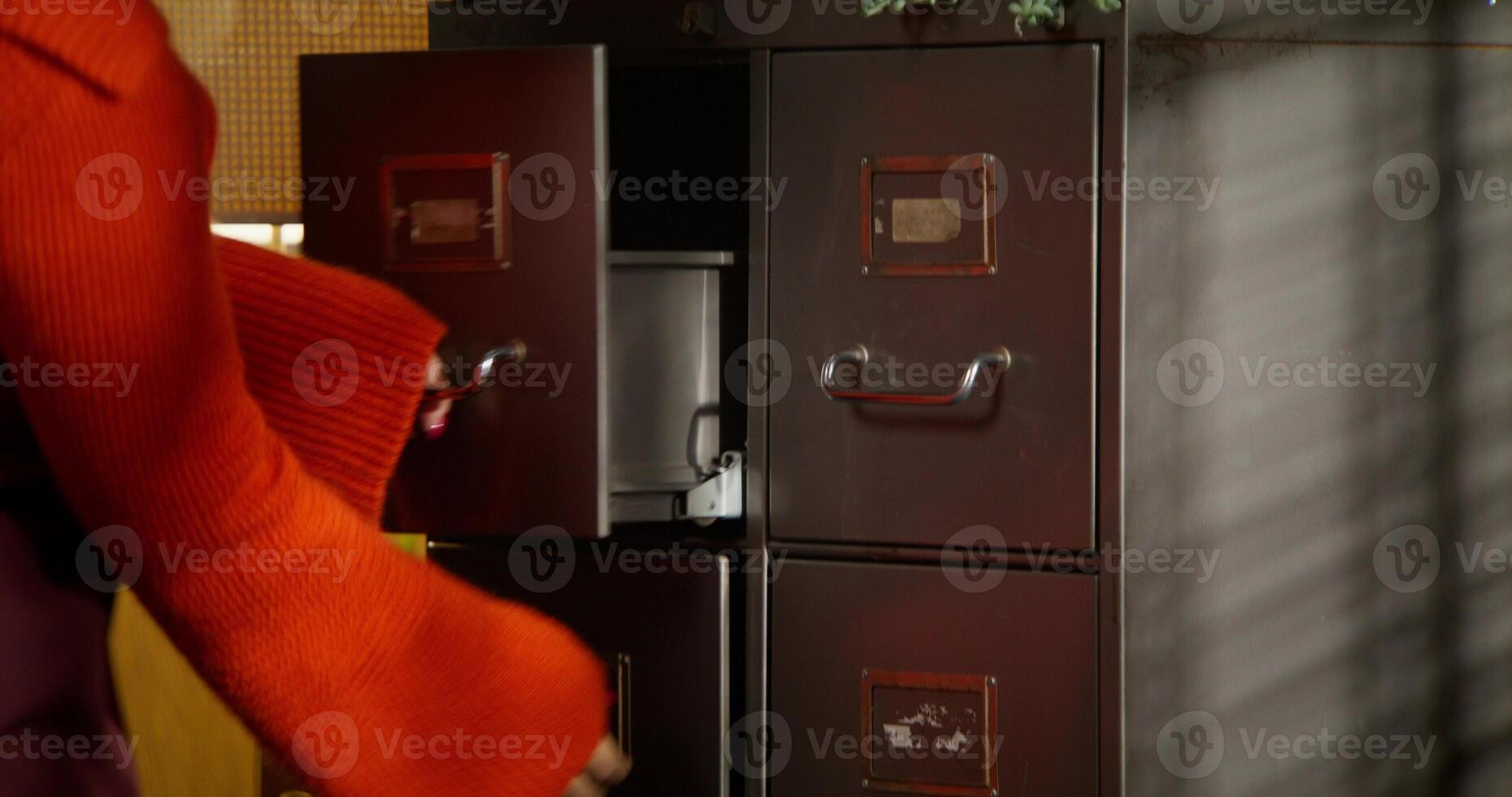 A woman works in a retro office. She opens the closet and takes out the documents. photo