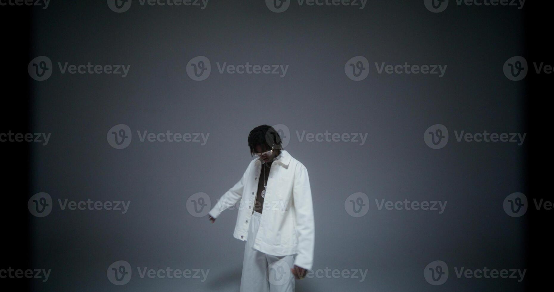 A man is dancing and singing in the studio. He looks at the camera with serious look. Recording music photo