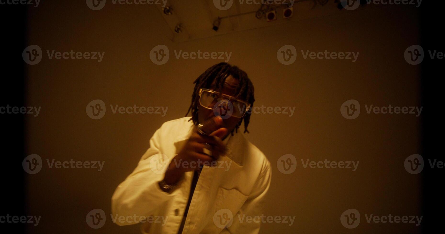 A stylish man raps while looking at the camera. Filming a musi c photo