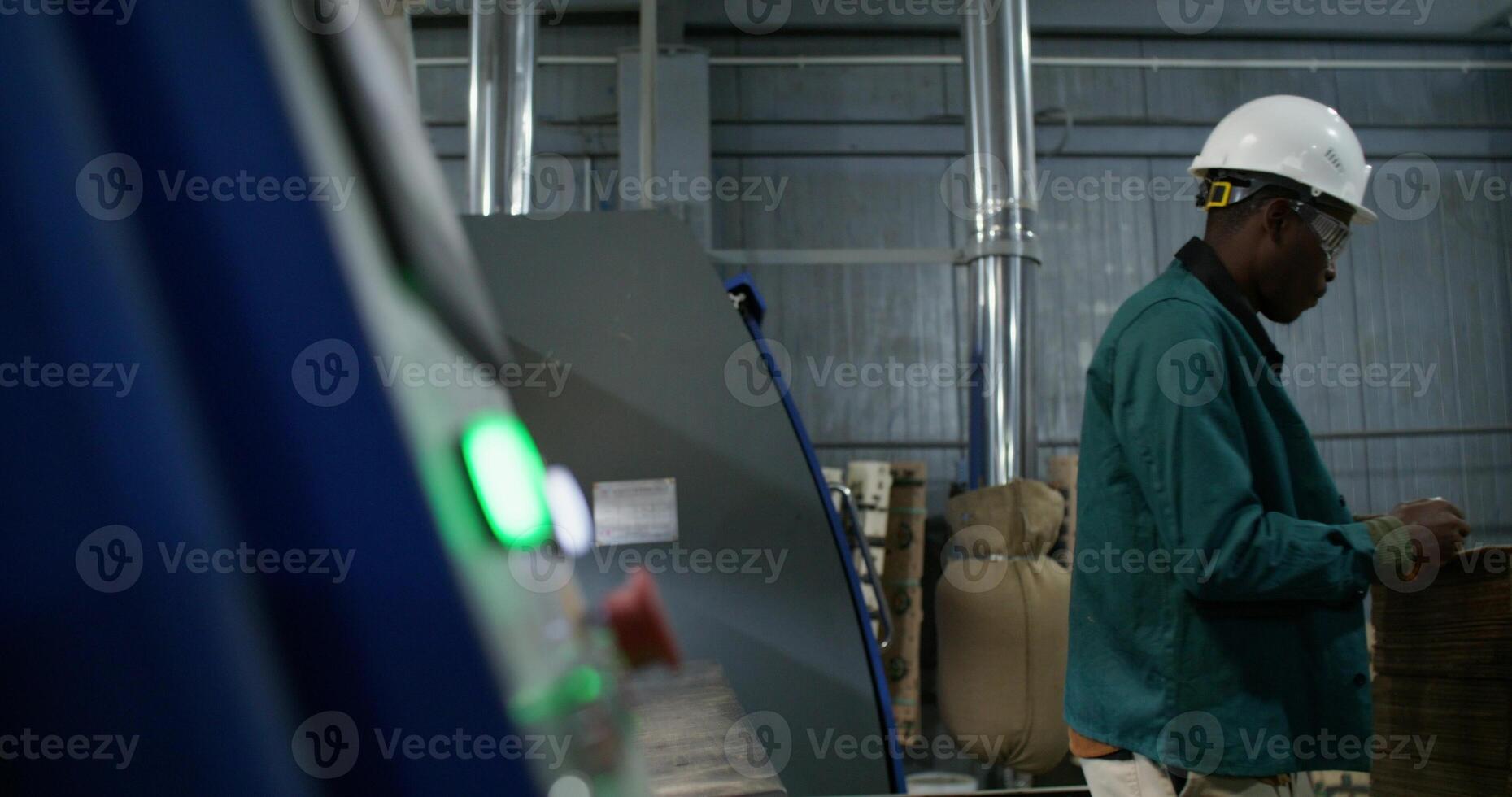 A man in protective gear works at a paper mill. photo