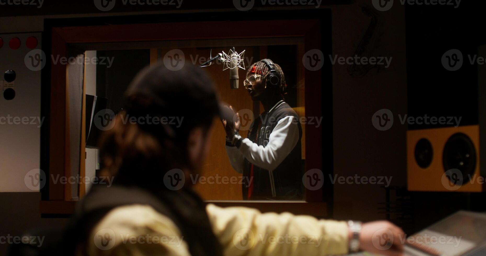 A sound engineer uses an audio mixer while recording a song in the studio. photo