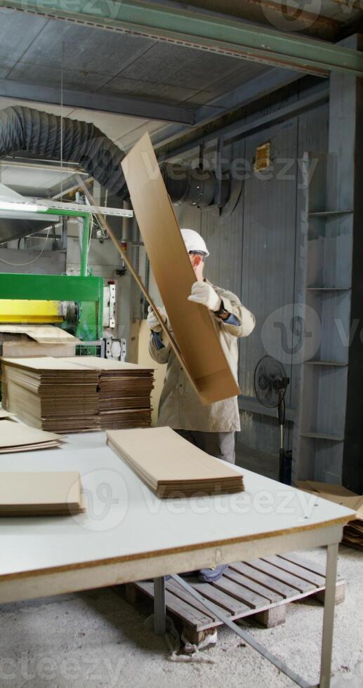 A man works in a paper mill. He talks to his colleague photo