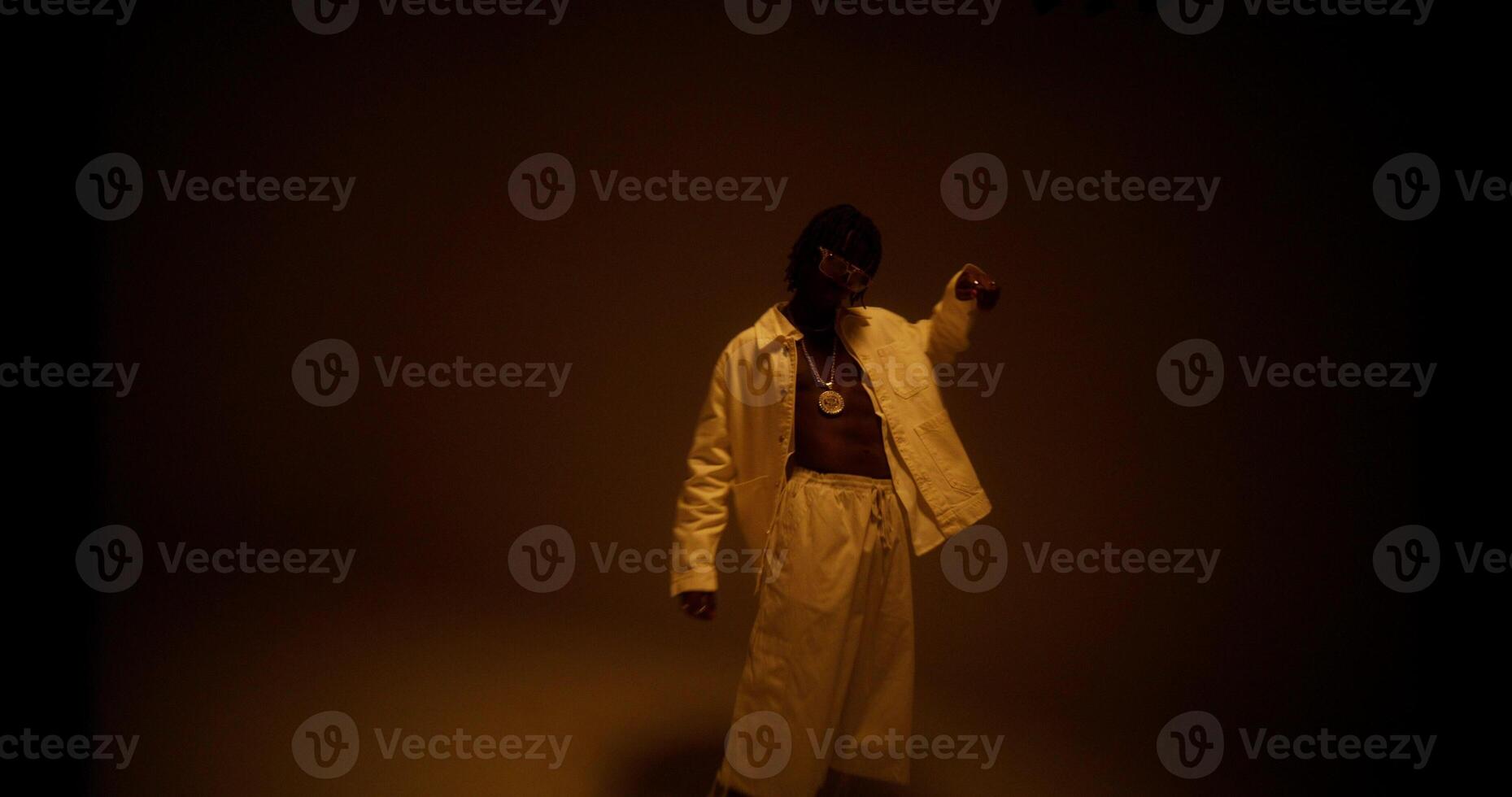 An African-American man is dancing in the studio by the light photo