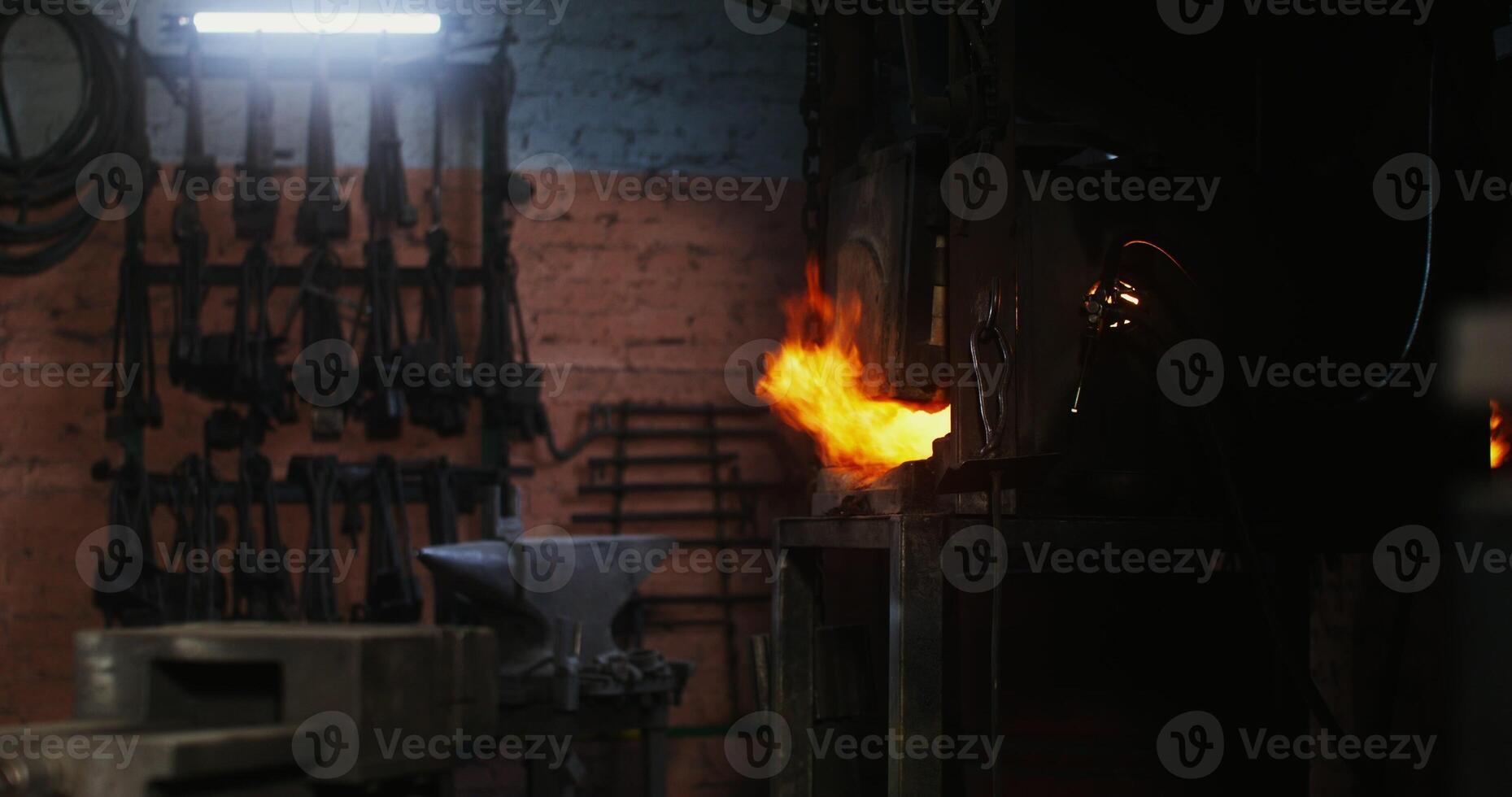 Kindled fire in the blacksmith's furnace. Side view of the flames emerging from the holes in the furnace. There are no people in the . 4k , red komodo - emerging photo