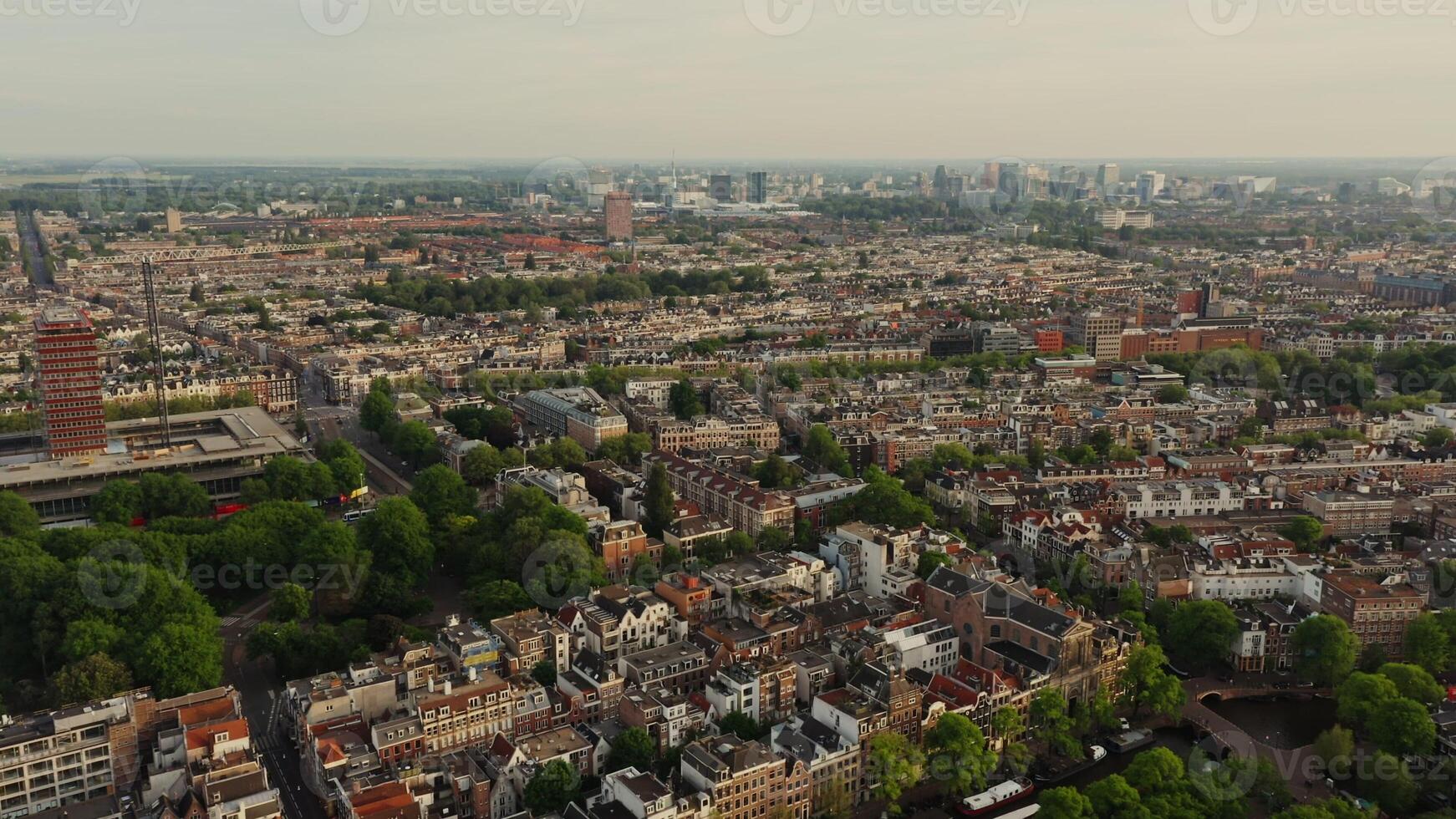 Top view of the Amsterdam canal between the streets with beautiful old traditional houses. Ships moored along the embankment, drone . Amsterdam, Netherlands photo