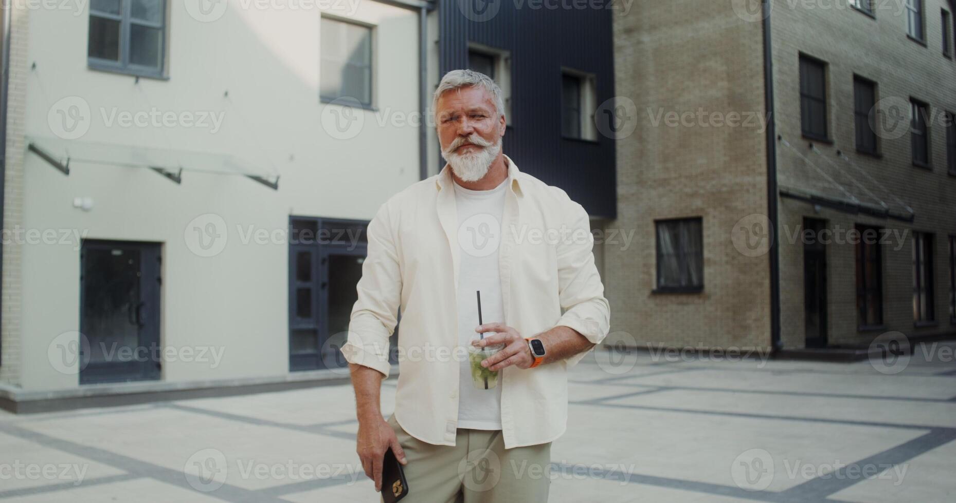 A mature man with gray hair standing on a city street photo