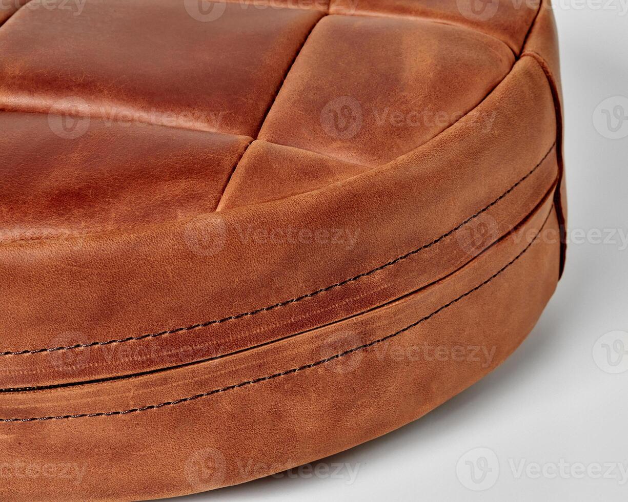 Round leather cushion showing detailed stitching and texture photo