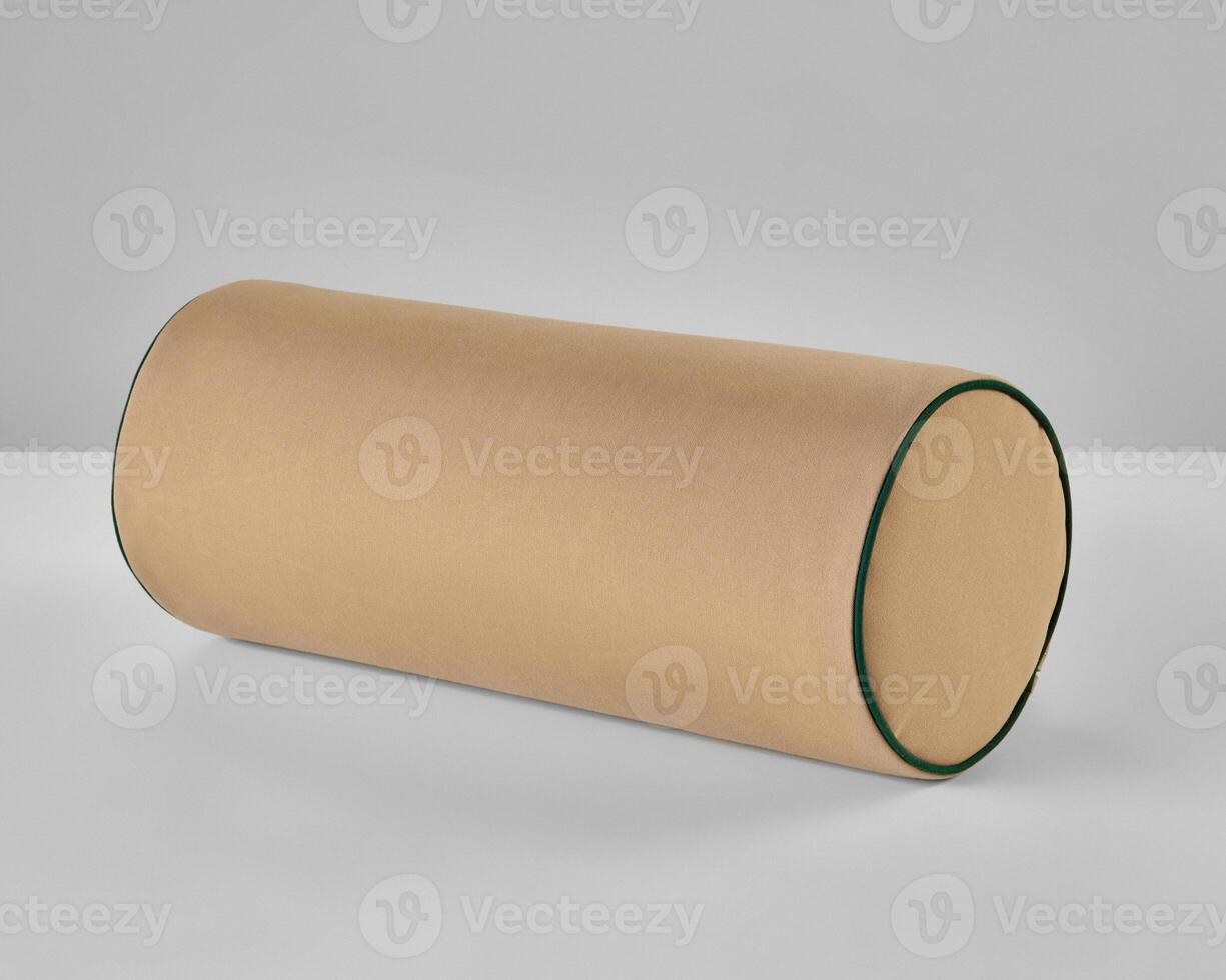 Beige bolster pillow with green border resting on white surface photo