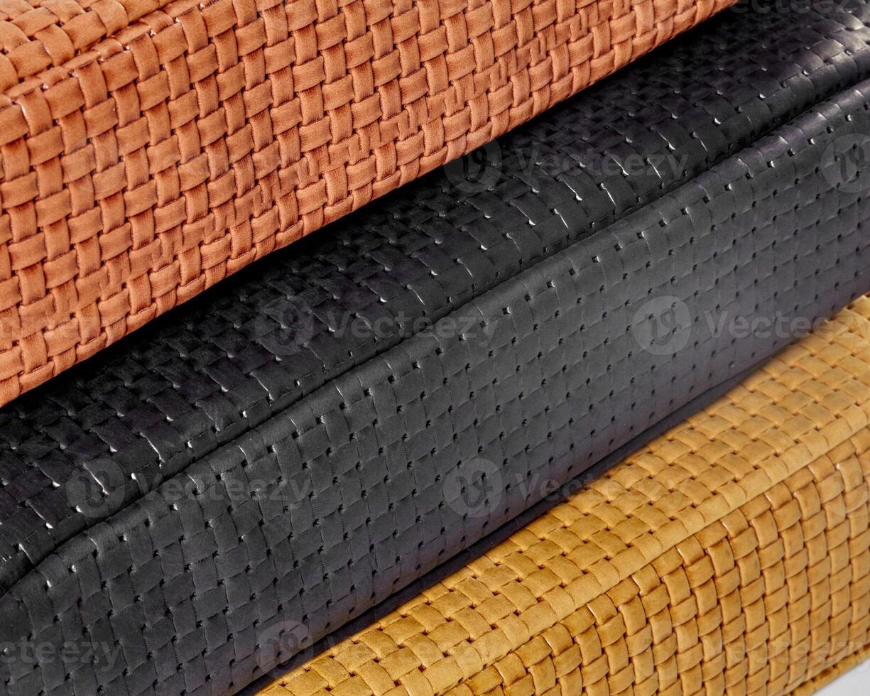 Stacked woven leather samples showing different colors and textures photo