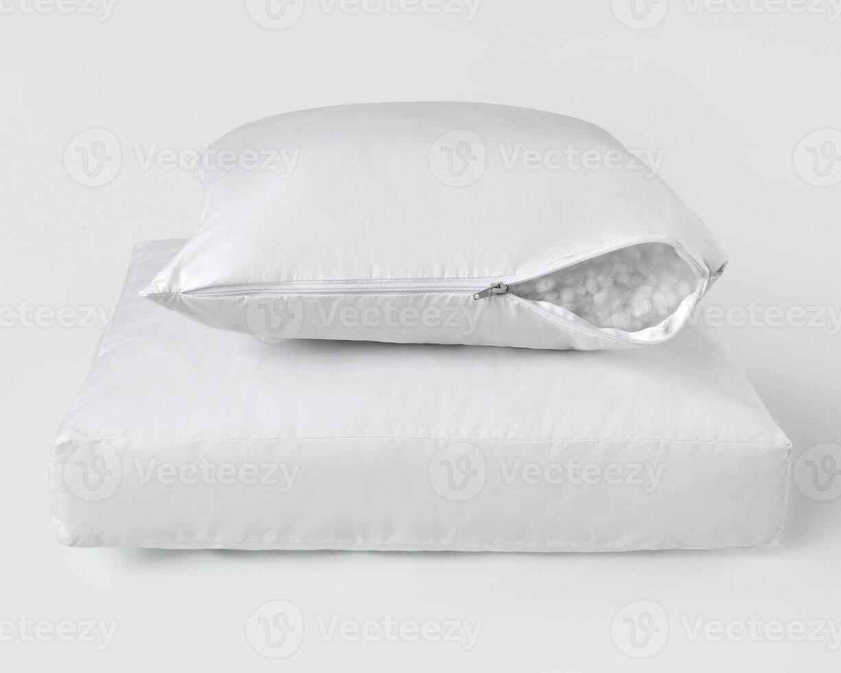 White pillow with open zipper revealing filling material resting on another pillow photo
