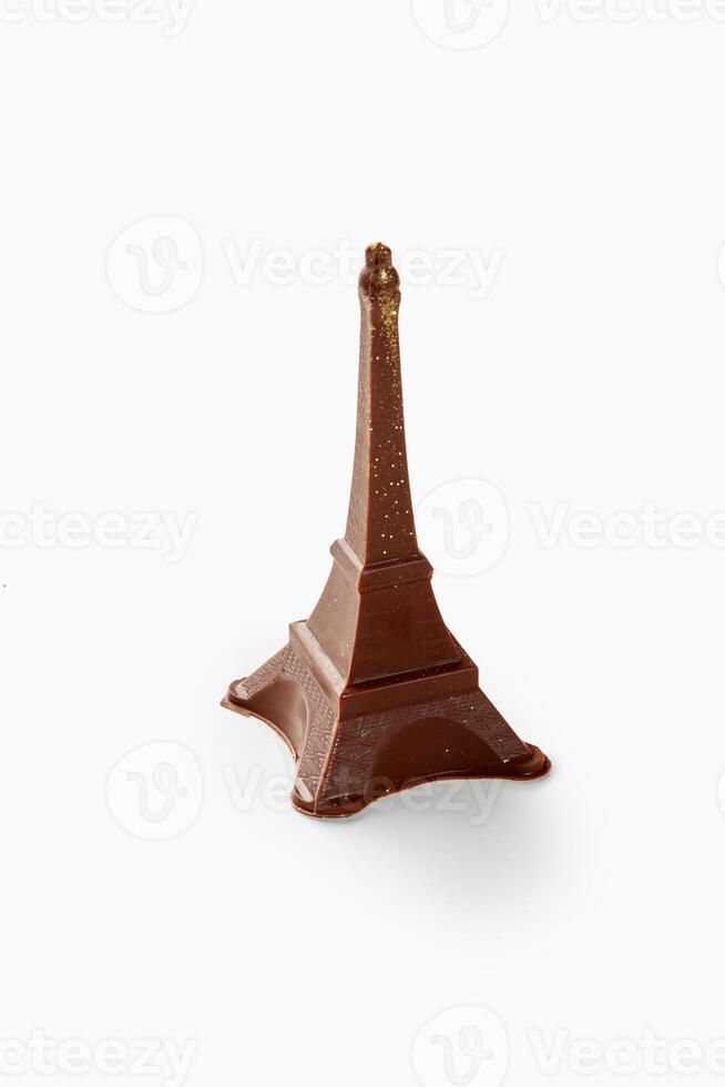 Chocolate eiffel tower sparkling with gold dust on white background photo