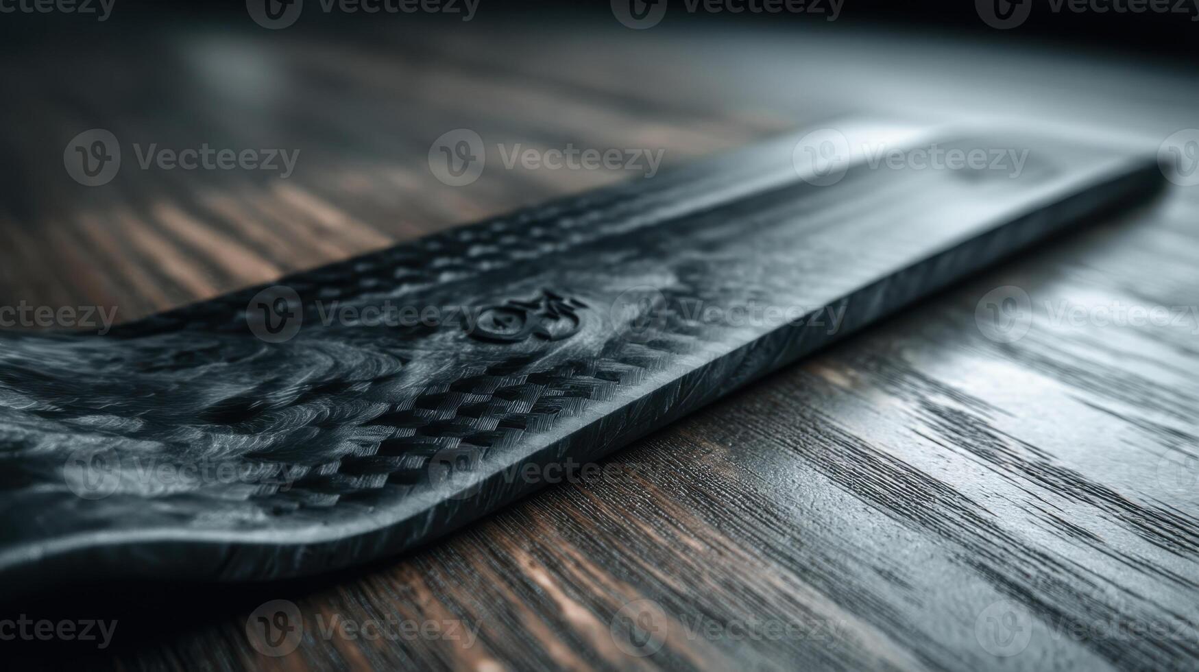 Carbon fiber sheet displaying intricate laser etching on wooden surface photo