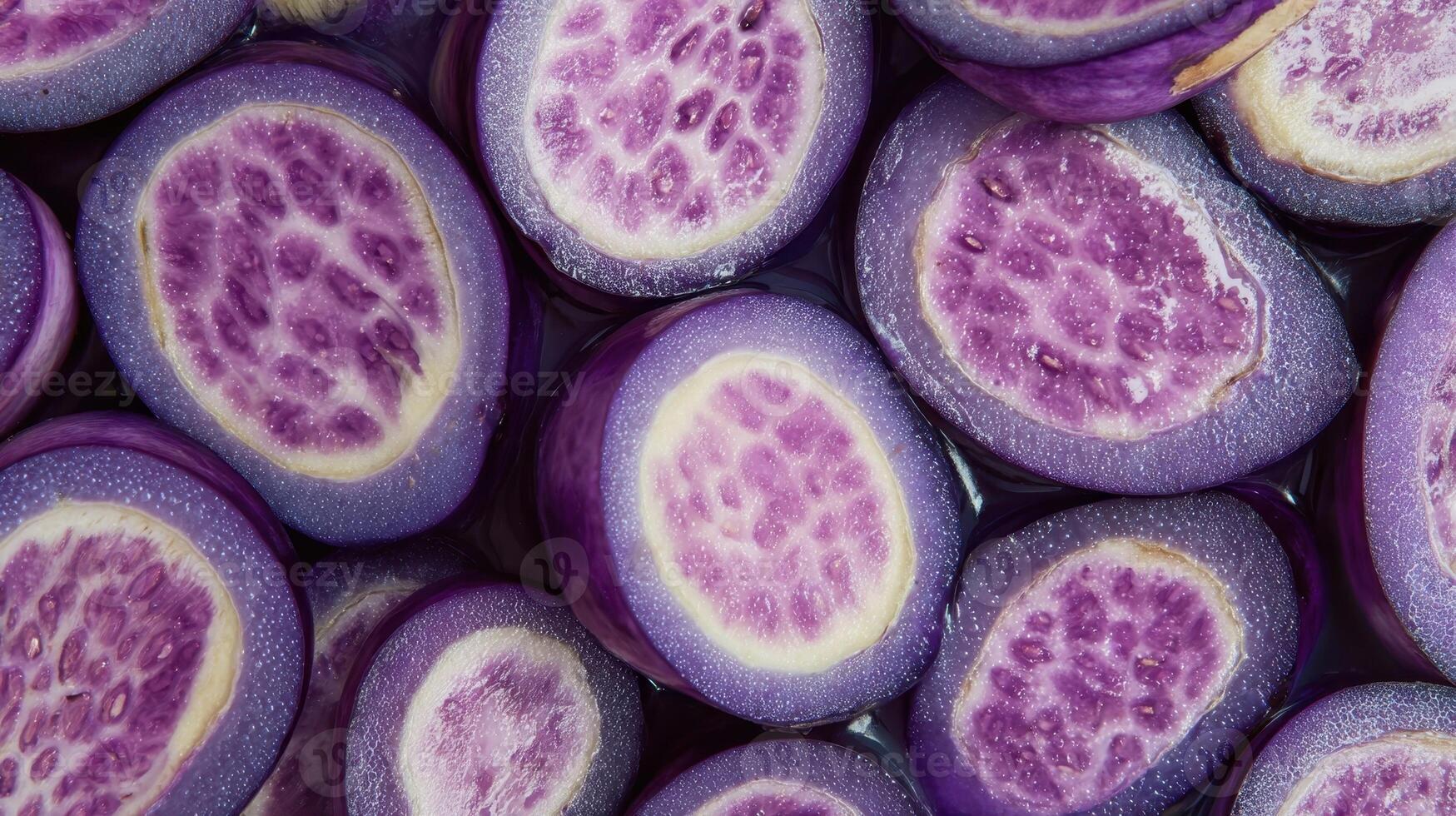 Close up of glossy purple eggplant slices showing vibrant inner texture and color photo