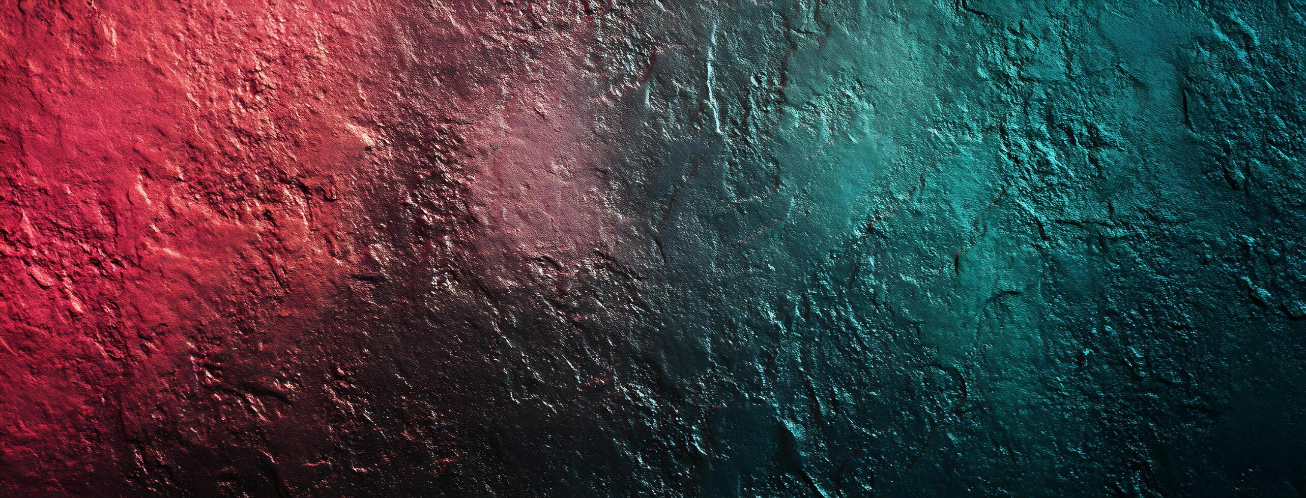 A rough stone surface displays a striking gradient from red to teal colors beautifully photo