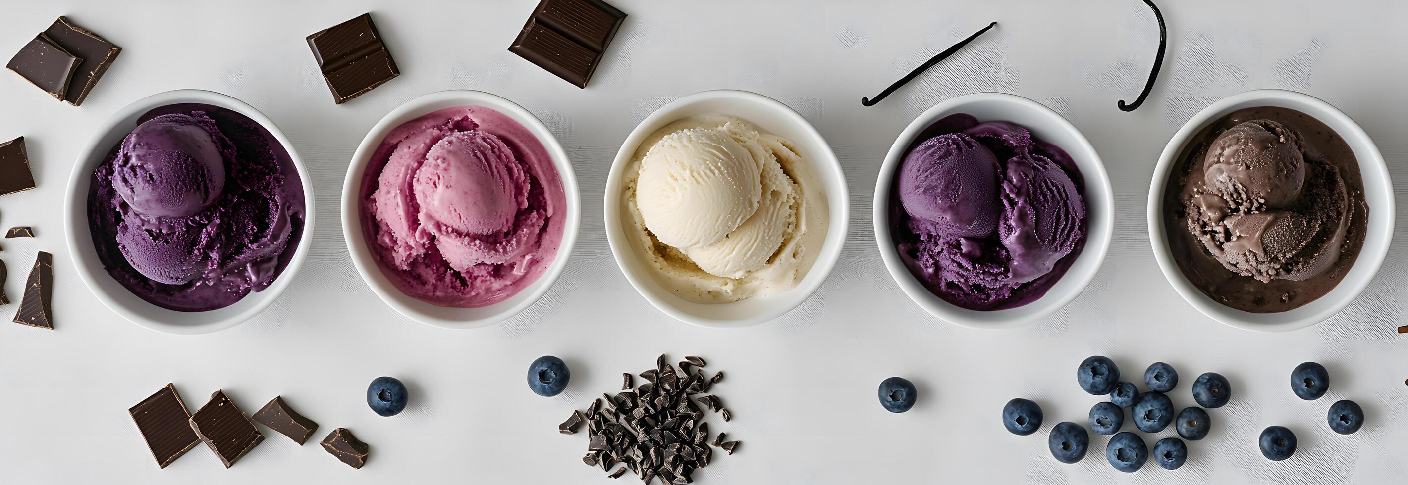 Diverse flavored ice cream bowls are arranged with fresh blueberries and rich chocolate pieces on white photo