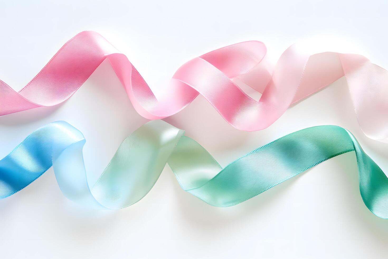 Pink and blue ribbons elegantly curve across the pristine white surface, displaying soft pastel hues photo