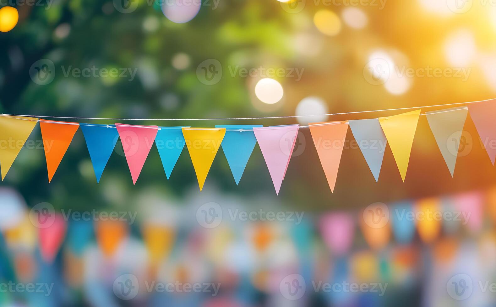 Colorful triangular bunting hangs in a festive outdoor setting with natural sunlight and bokeh photo