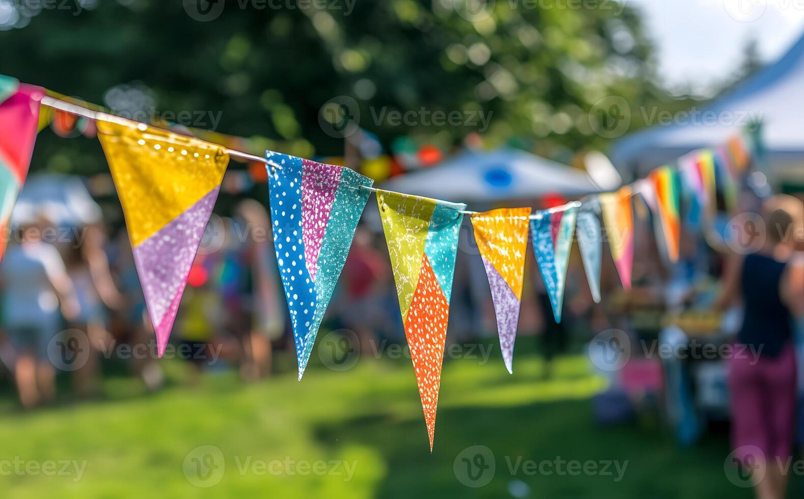 Festive triangle flags with colorful designs strung across outdoor event create a lively atmosphere photo