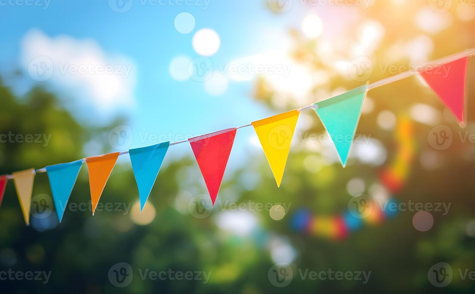 Festive party pennants strung between trees create a joyous, colorful outdoor atmosphere on a bright day photo