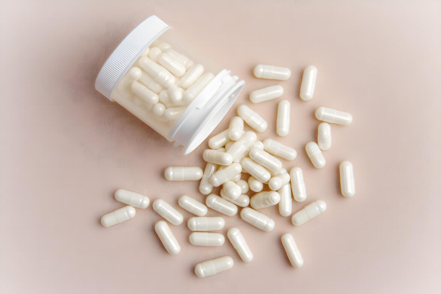 White capsules spill from an open translucent bottle onto a textured, neutral background photo