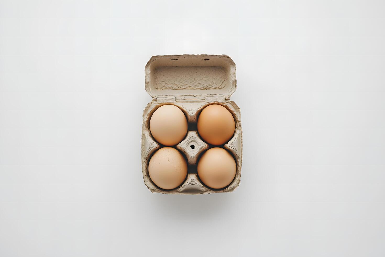 Four organic eggs sit nestled inside a partially opened carton on a simple background photo