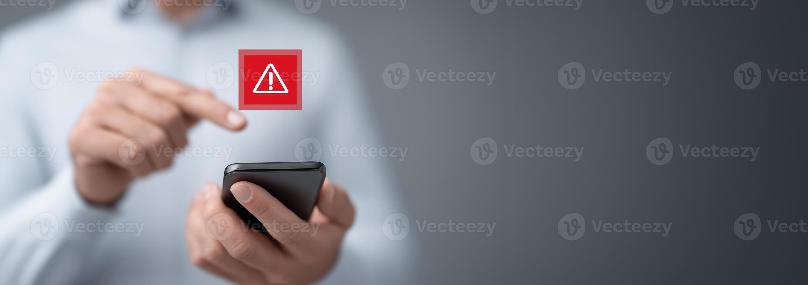 A man is holding a phone with a red warning icon photo