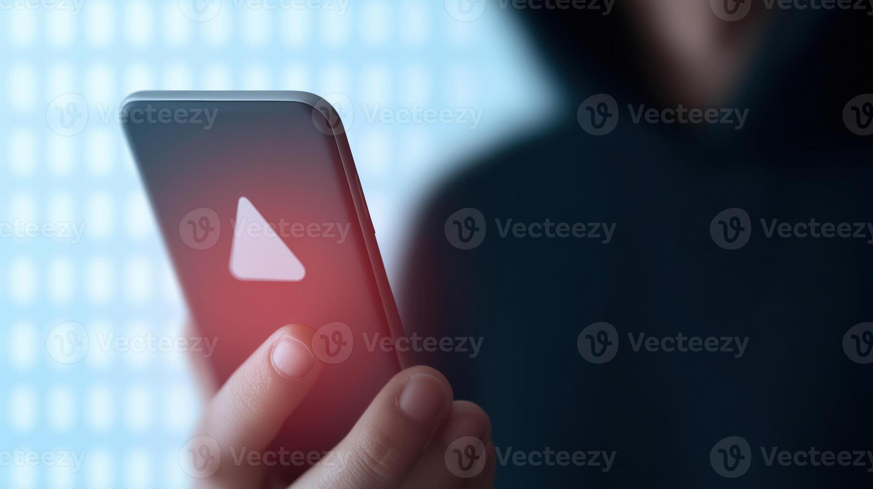 A person holding a smartphone with a red triangle on the screen photo