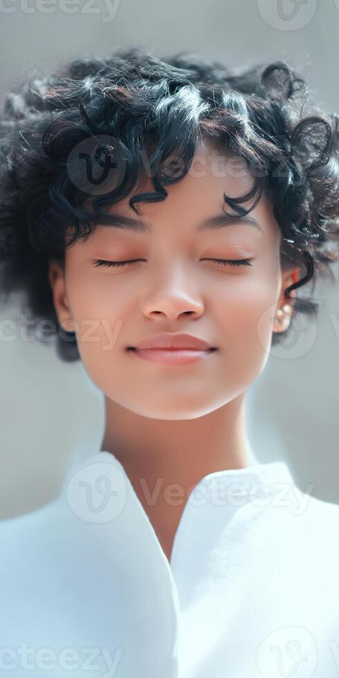 A woman with her eyes closed and her hair in a bun photo