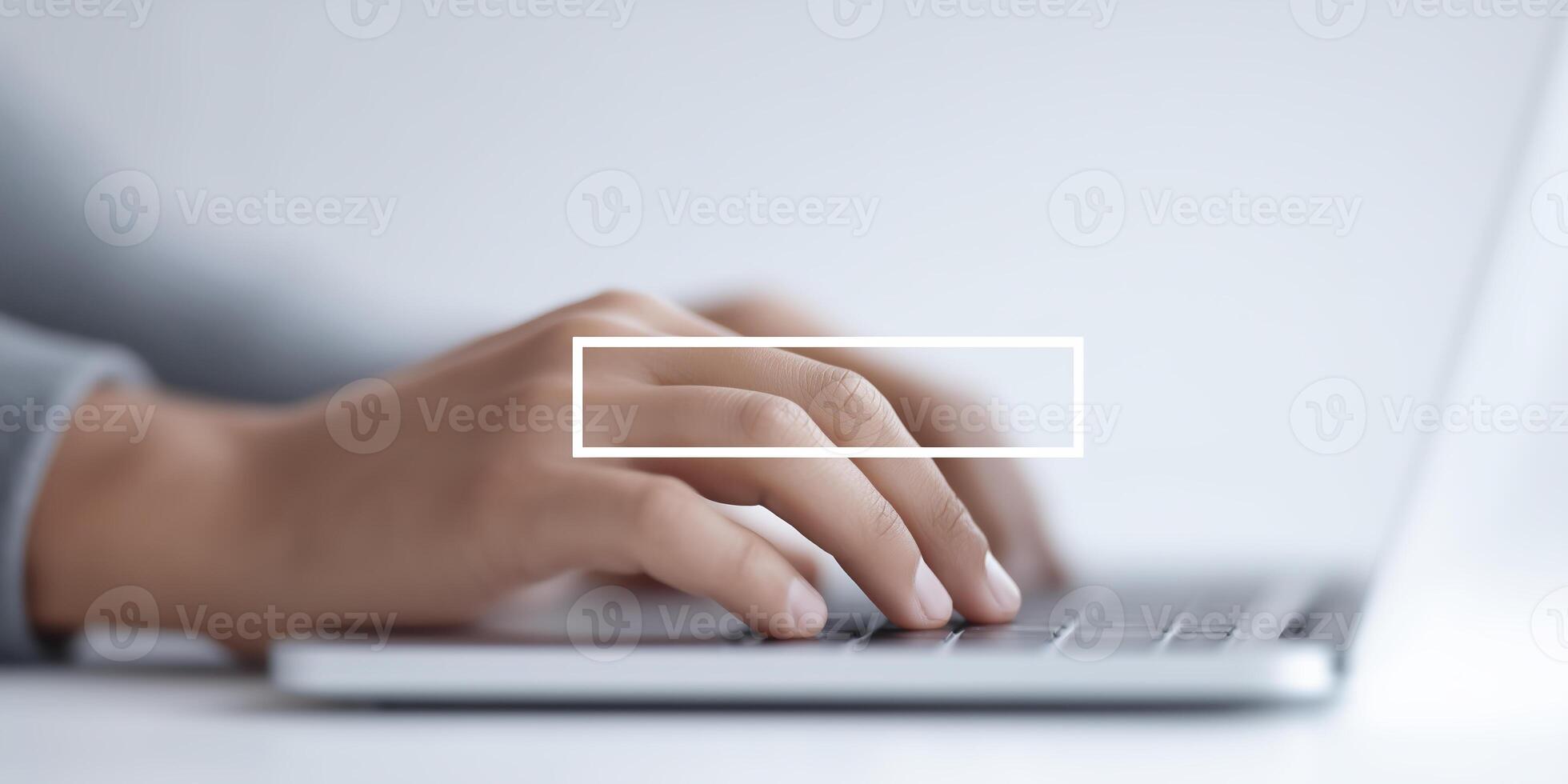 A person typing on a laptop with a white box on the screen photo
