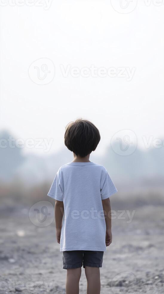 A young boy standing in the middle of a field photo