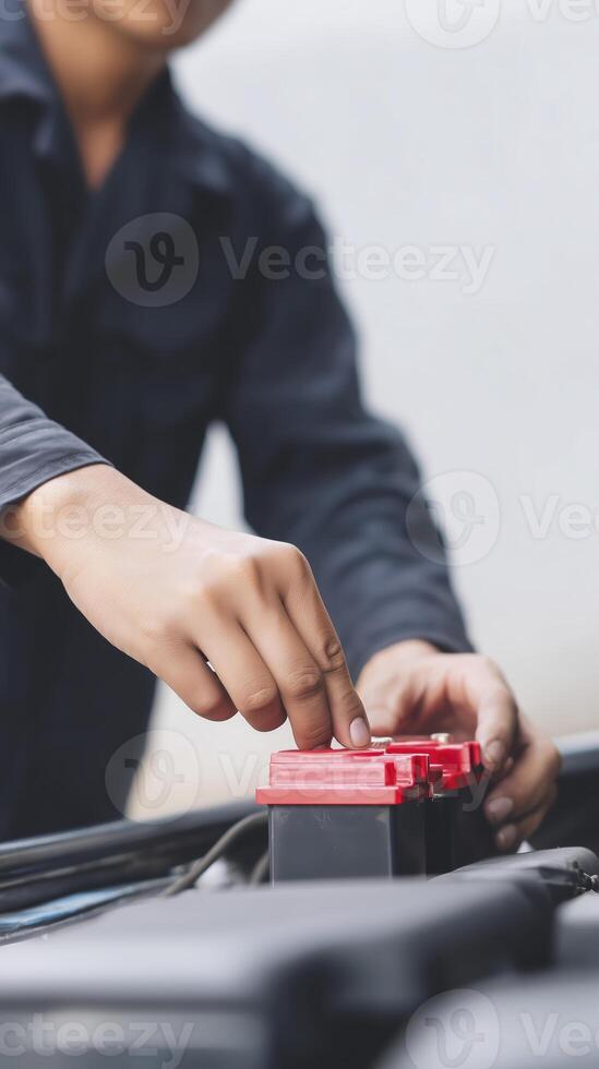 Skilled automotive technician is replacing a car battery in a vehicle engine compartment, showcasing hands-on expertise and attention to detail in automotive maintenance and repair tasks photo