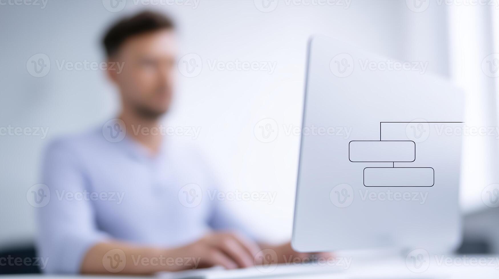 Professional man working on computer with flowchart graphic on screen in modern office environment showcasing productivity and focus on task completion photo