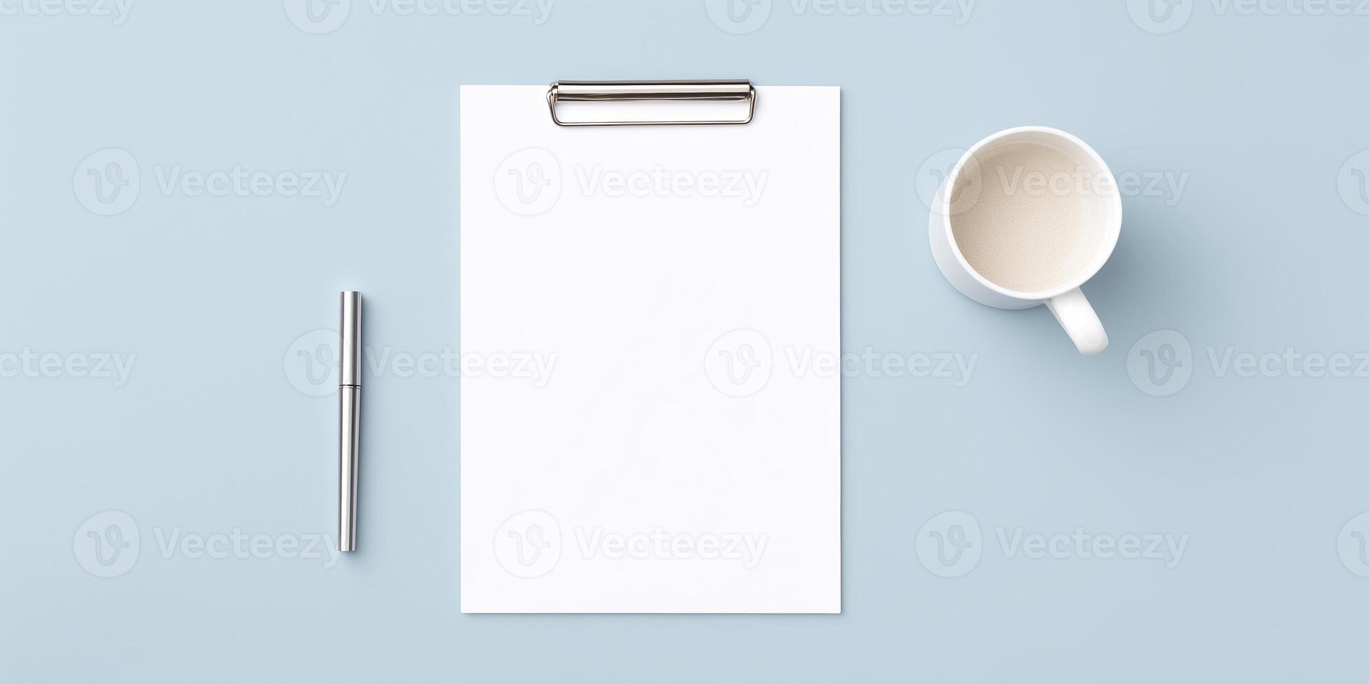 Blank clipboard with white sheet of paper, silver pen, and white coffee mug on a light blue background creating a minimalistic workspace atmosphere photo