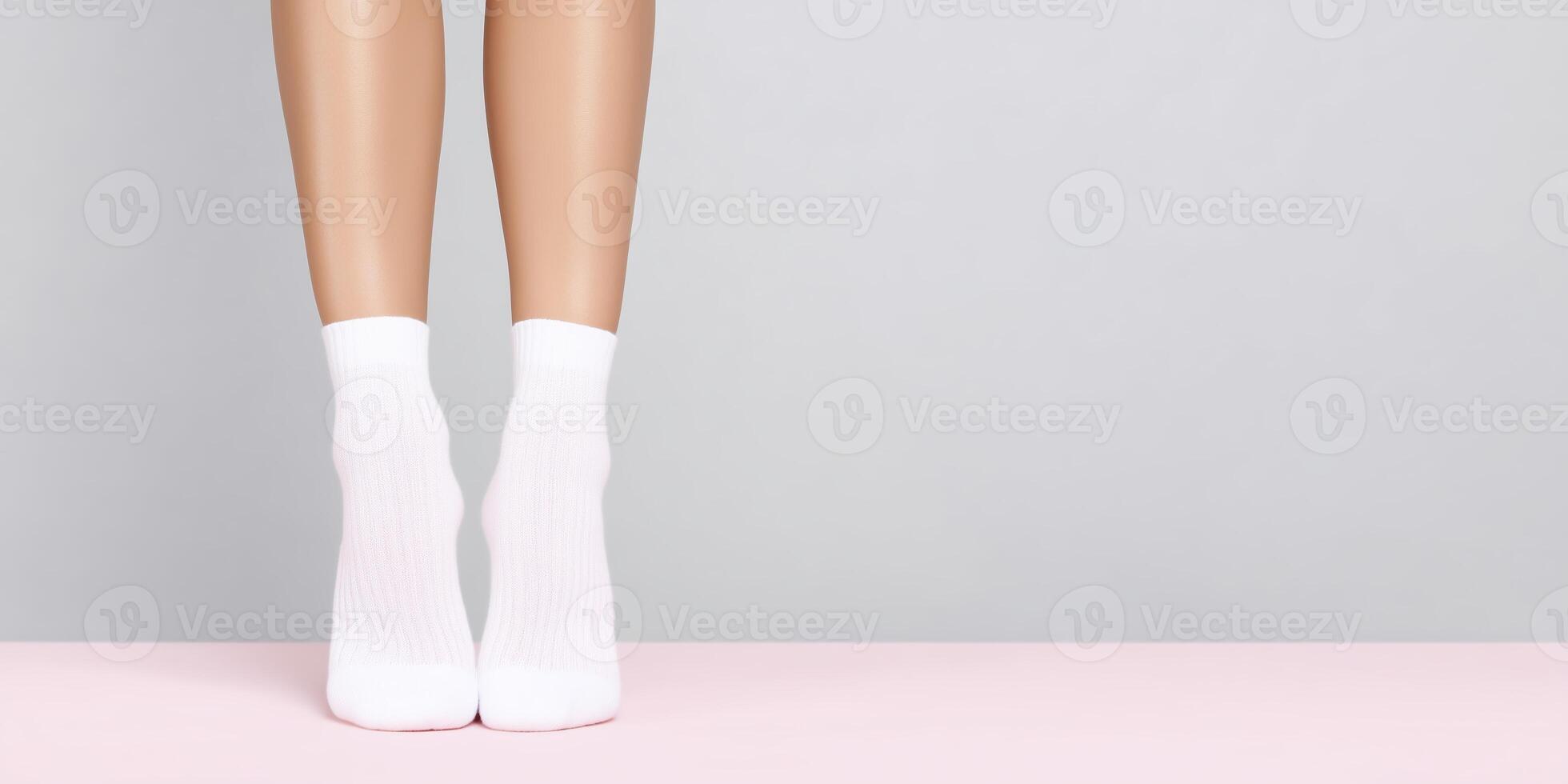 Female legs wearing white socks standing on a pink surface against a soft gray background with a minimalist aesthetic and modern design elements photo