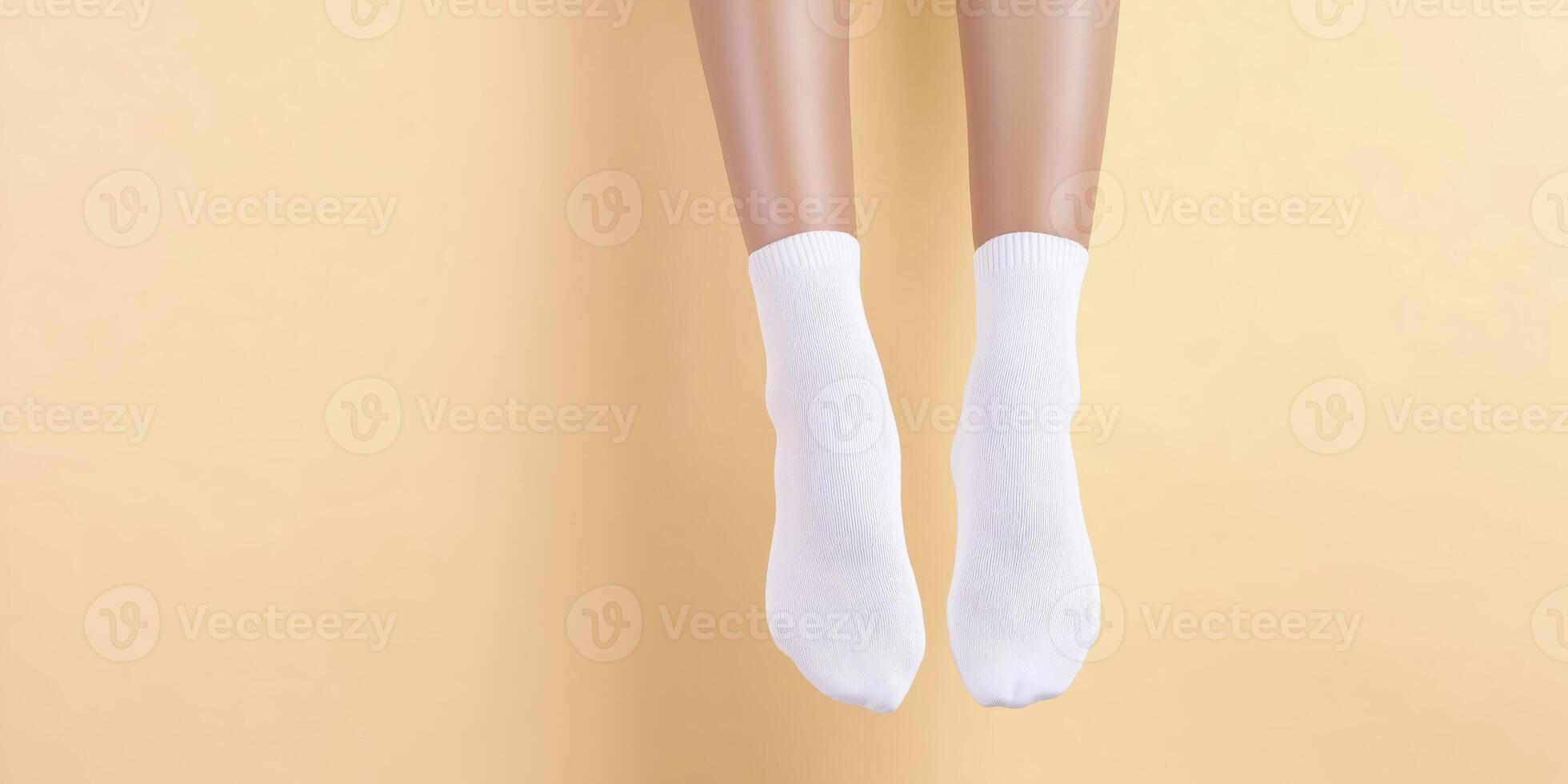 White socks on mannequin feet are suspended against a soft yellow background, showcasing a minimalist design ideal for fashion and textile presentations photo