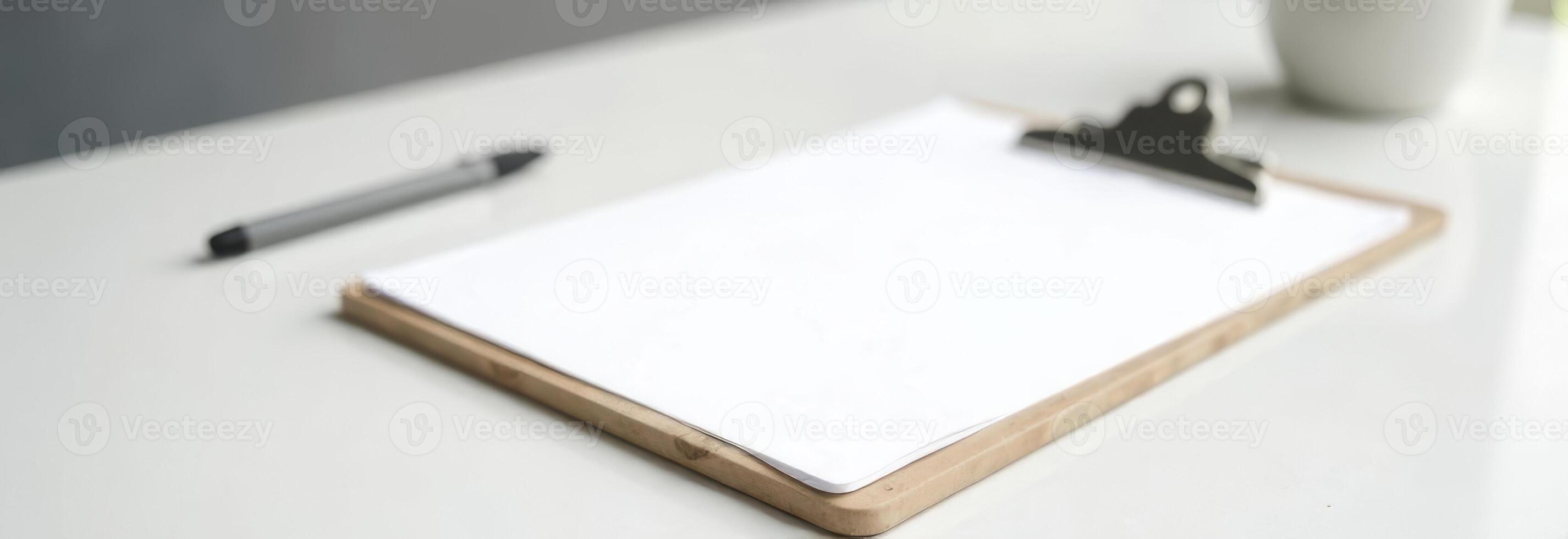 Blank clipboard on a clean desk with a pen and a cup, ideal for notes and ideas, workspace organization concept photo