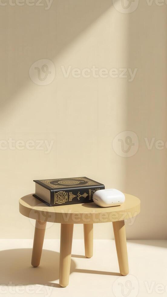 Quran and wireless headphones resting on wooden stool in sunlight photo